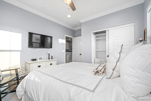 bedroom featuring ceiling fan, ornamental molding, a closet, and multiple windows