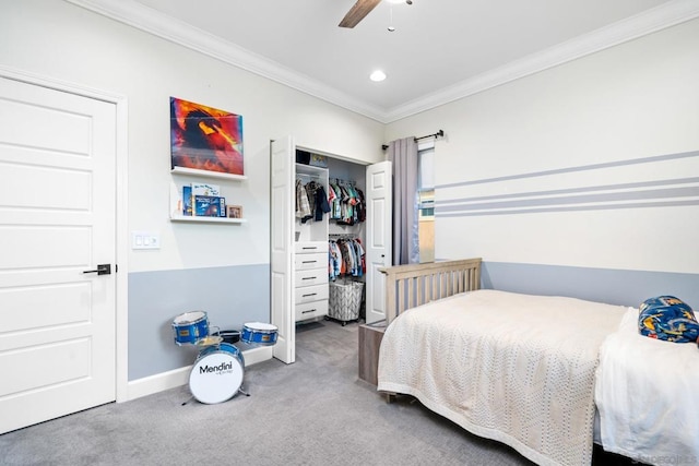 carpeted bedroom with ceiling fan, a closet, and crown molding