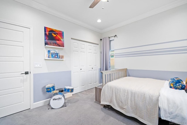 carpeted bedroom featuring ceiling fan, a closet, and ornamental molding