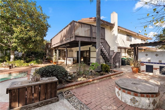 rear view of house with a patio and a wooden deck