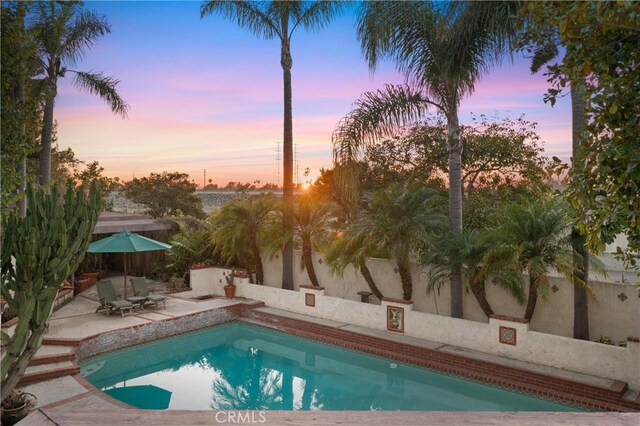 pool at dusk with a patio