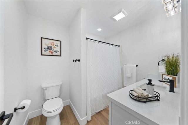 bathroom with vanity, hardwood / wood-style floors, toilet, and walk in shower