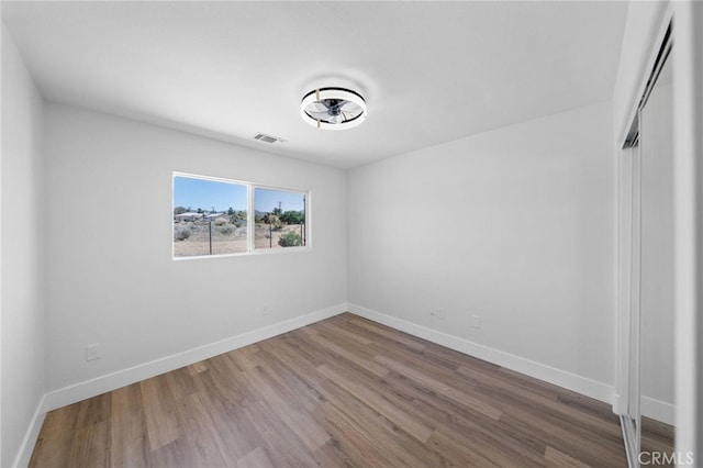 unfurnished room with hardwood / wood-style flooring