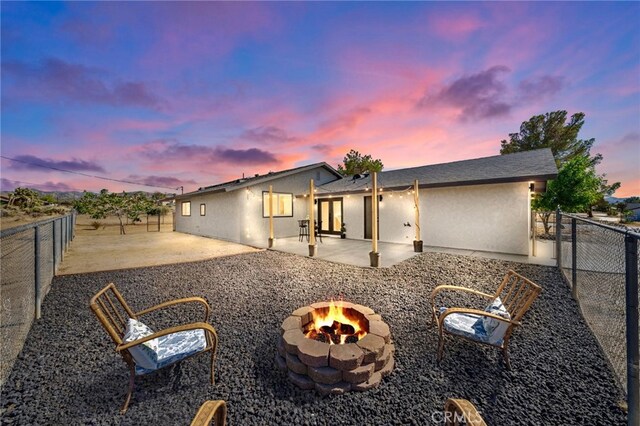 ranch-style house featuring a patio area and a fire pit