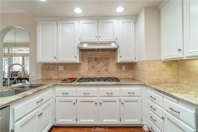 kitchen with light stone counters, tasteful backsplash, white cabinetry, appliances with stainless steel finishes, and sink