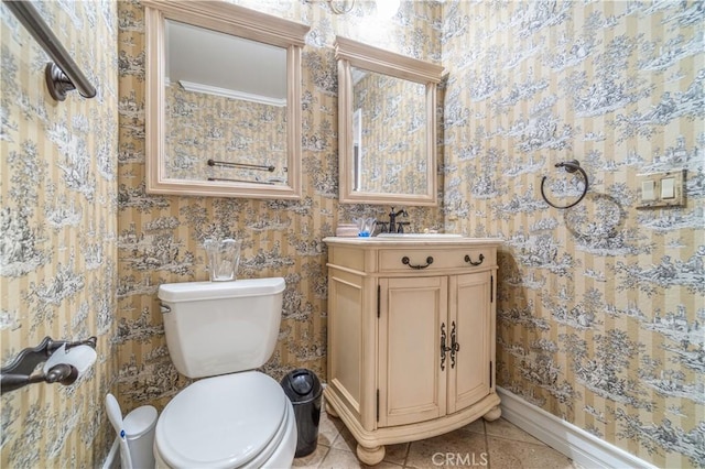 bathroom with toilet, vanity, and tile patterned floors