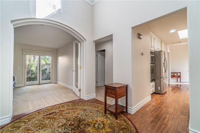 corridor with french doors and light wood-type flooring