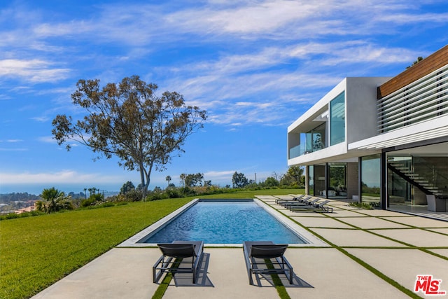 view of swimming pool with a patio area and a lawn