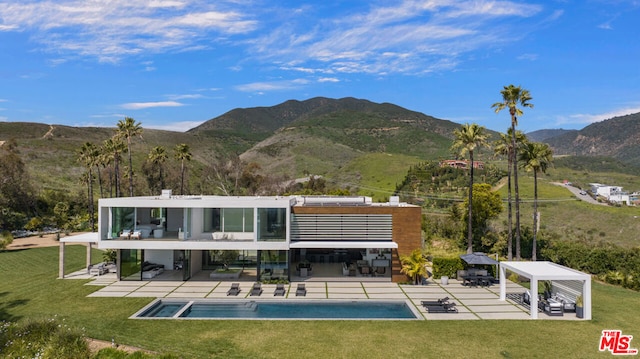 rear view of house featuring a balcony, a mountain view, and a patio