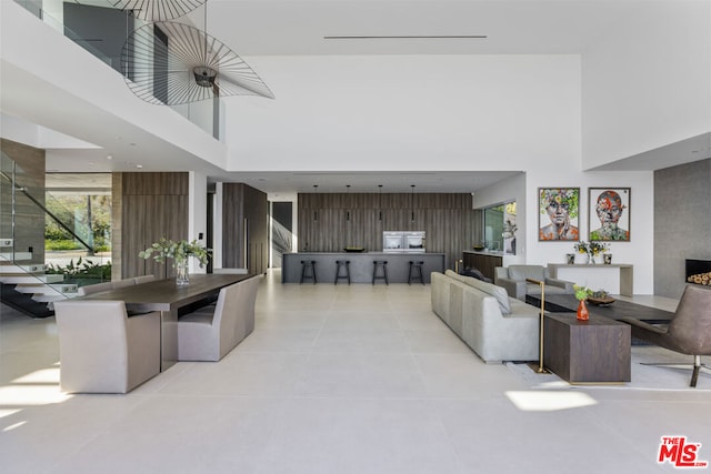 living room featuring light tile patterned floors and a towering ceiling