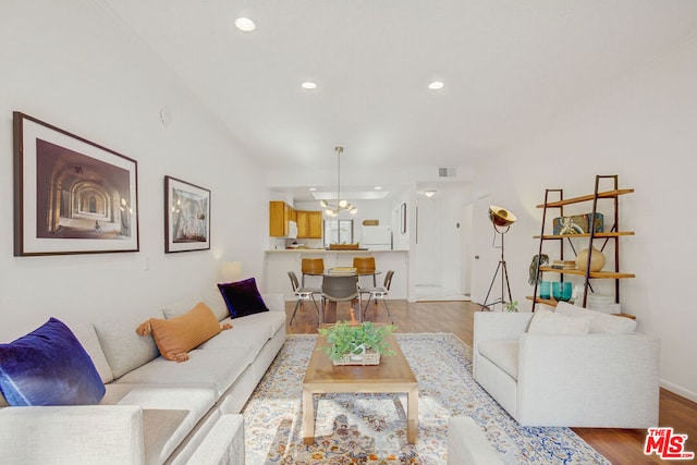 living room featuring light hardwood / wood-style flooring and an inviting chandelier