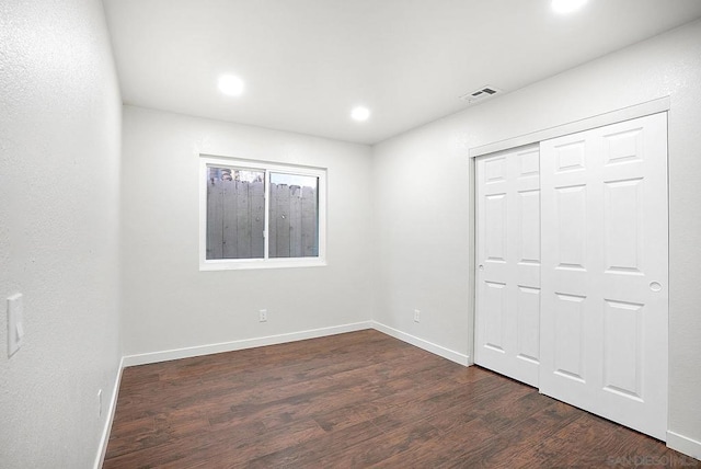 unfurnished bedroom with a closet and dark hardwood / wood-style floors