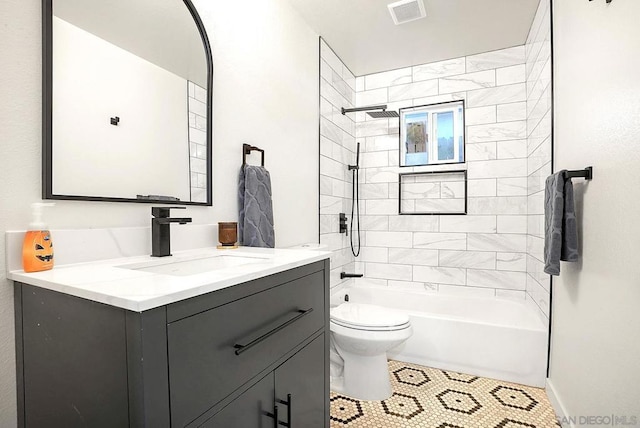 full bathroom featuring toilet, tile patterned flooring, tiled shower / bath, and vanity