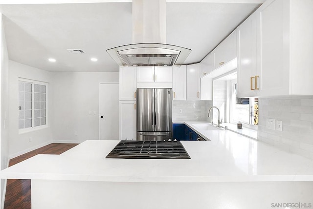 kitchen with sink, white cabinets, stainless steel fridge, and island range hood