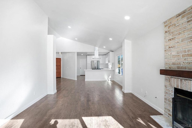 unfurnished living room featuring lofted ceiling, a fireplace, and dark wood-type flooring