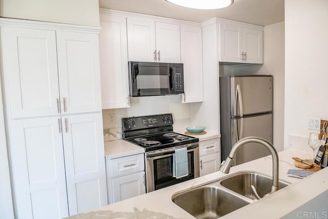 kitchen featuring light stone counters, sink, white cabinetry, and stainless steel appliances