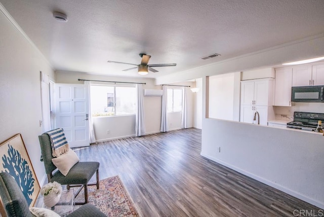 living area featuring ceiling fan, sink, crown molding, a textured ceiling, and dark hardwood / wood-style flooring