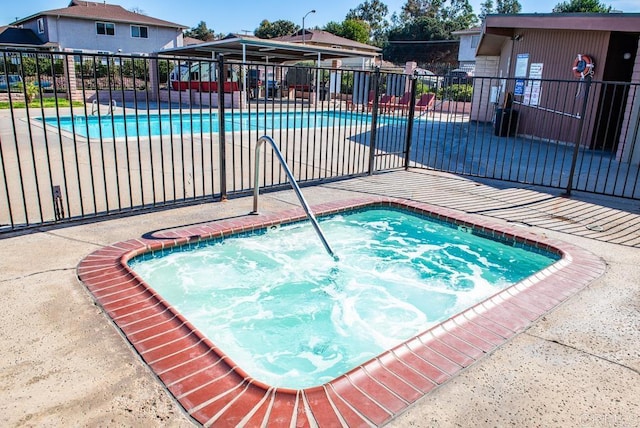 view of swimming pool with a patio area and a community hot tub