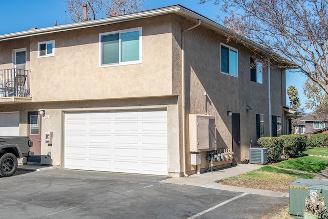 exterior space featuring central AC unit and a garage