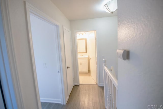 hallway with light hardwood / wood-style floors