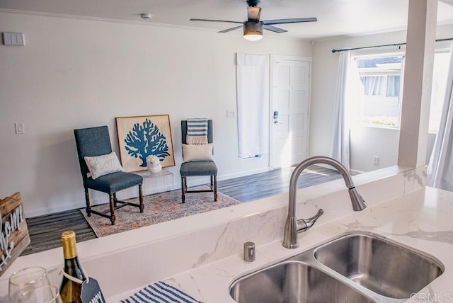 kitchen featuring crown molding, ceiling fan, sink, and light stone counters