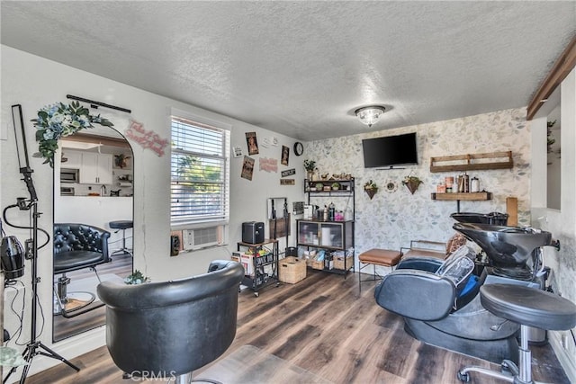 living room featuring cooling unit, wood-type flooring, and a textured ceiling