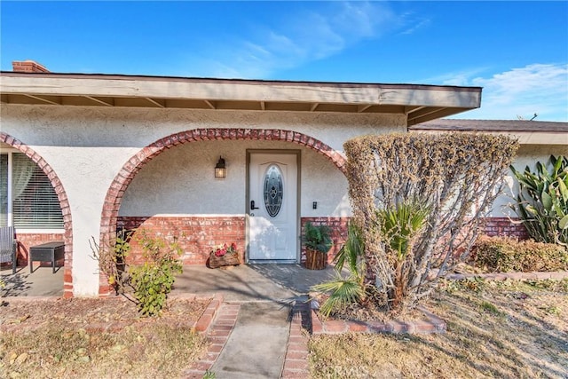 view of exterior entry with a patio