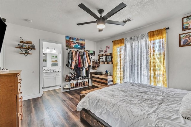 bedroom with ensuite bathroom, ceiling fan, dark hardwood / wood-style floors, and a textured ceiling