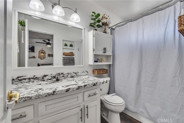 bathroom with hardwood / wood-style floors, vanity, toilet, and ceiling fan