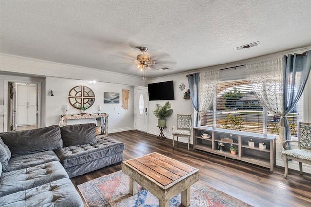 living room featuring ceiling fan, dark hardwood / wood-style flooring, and a textured ceiling