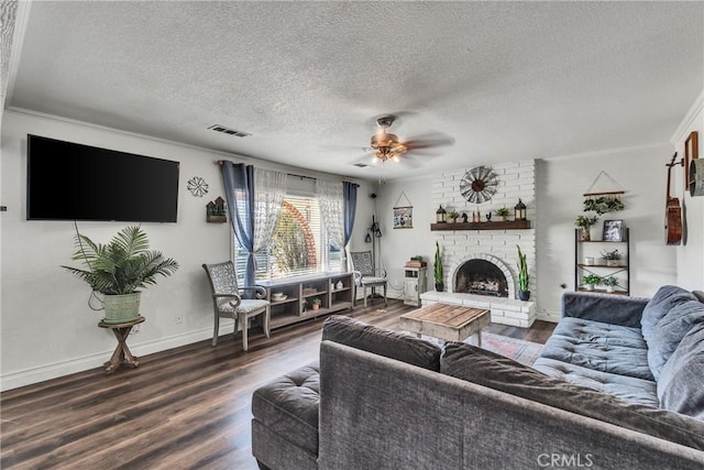 living room featuring ornamental molding, a textured ceiling, ceiling fan, hardwood / wood-style flooring, and a fireplace