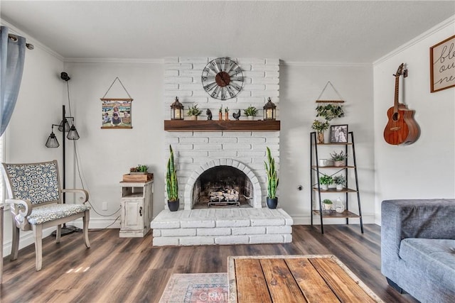 living room featuring dark wood-type flooring, crown molding, and a brick fireplace