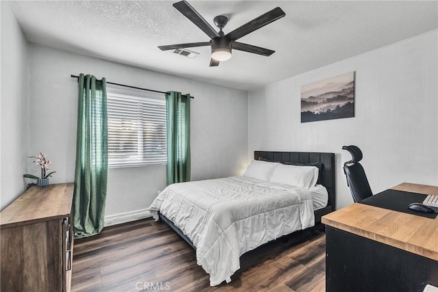 bedroom with a textured ceiling, dark hardwood / wood-style flooring, and ceiling fan