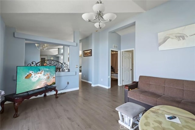 living room with hardwood / wood-style floors and a notable chandelier