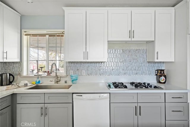 kitchen with gray cabinets, sink, tasteful backsplash, and white appliances