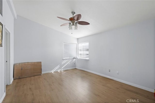 spare room featuring lofted ceiling, light wood-type flooring, and ceiling fan