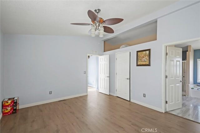 unfurnished bedroom featuring ceiling fan, lofted ceiling, and hardwood / wood-style floors