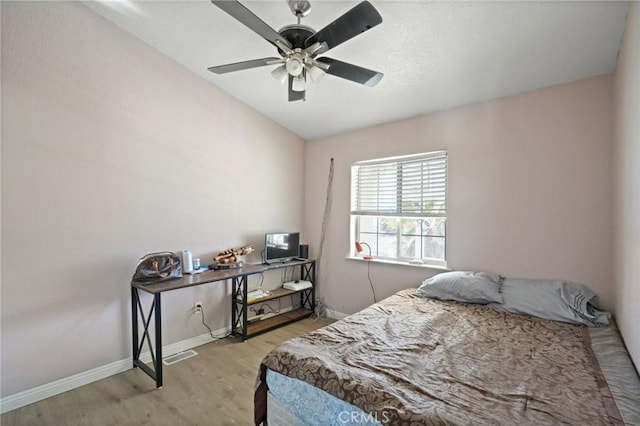 bedroom with ceiling fan, lofted ceiling, and light wood-type flooring