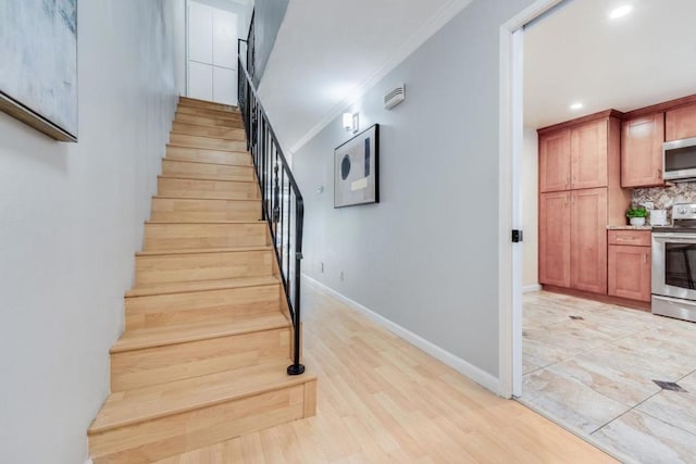 stairs with hardwood / wood-style flooring and crown molding