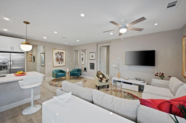 living room featuring ceiling fan and light wood-type flooring