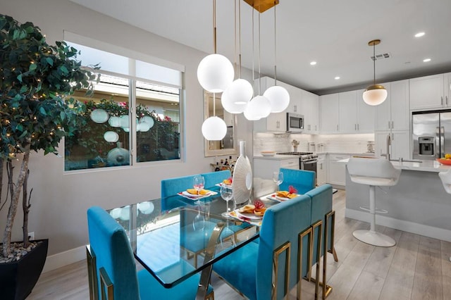 dining area with sink and light hardwood / wood-style flooring