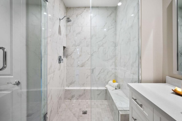 bathroom with a shower with shower door and vanity