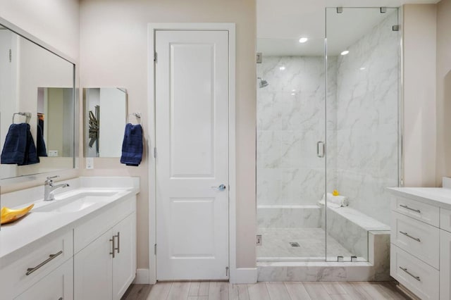 bathroom with vanity and a shower with door