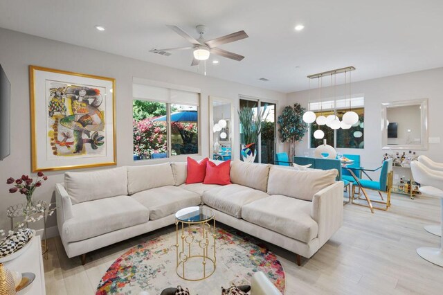 living room featuring ceiling fan and light hardwood / wood-style flooring