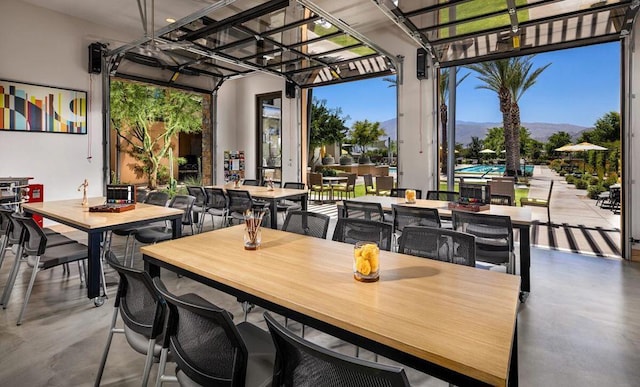 dining space with concrete flooring and a mountain view