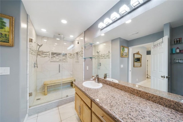 bathroom with walk in shower, vanity, and tile patterned floors