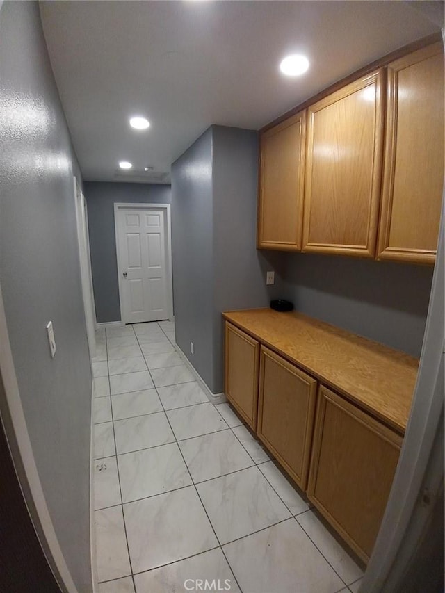 hallway with marble finish floor, baseboards, and recessed lighting