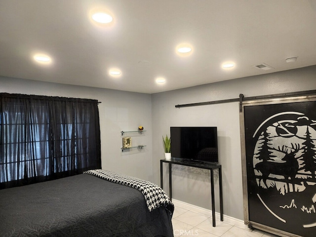 tiled bedroom featuring a barn door