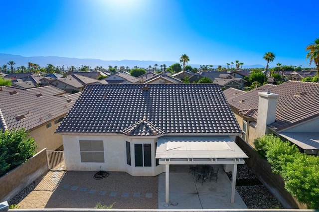 rear view of house with a mountain view and a patio