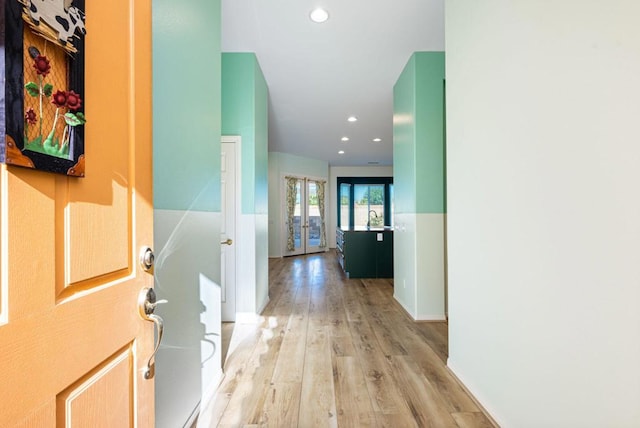 corridor featuring sink, french doors, and light wood-type flooring